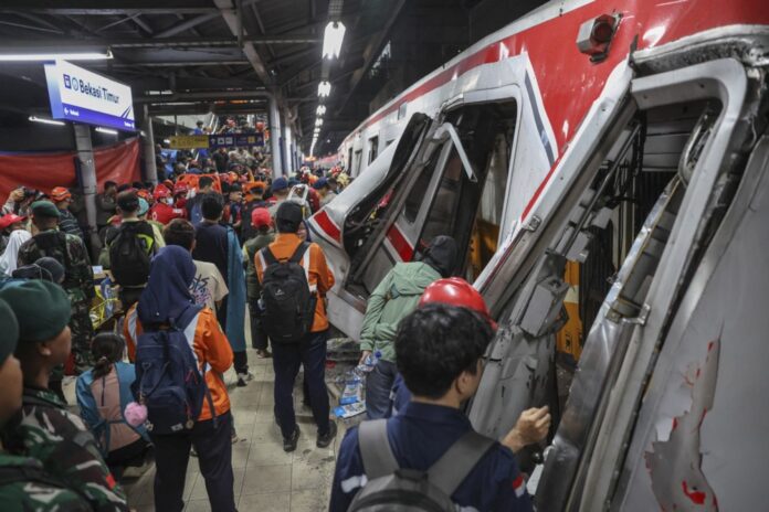 Rescue personnel evacuate trapped passengers after train collision in Indonesia