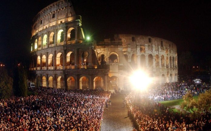 People gather at Rome's Colosseum before the arrival of Pope John Paul II for the Via Crucis (Way of the Cross) torchlight procession