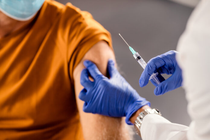 Close-up of healthcare worker giving a vaccine to senior patient